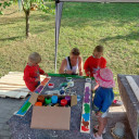 Bunte Zaunslatten werden bemalt