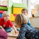 Knder spielen gemeinsam ein Holzspiel